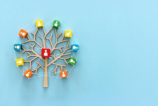 NCADA Launches New AMS and Website to Streamline Member Experience; Wooden tree with multicolored blocks and people icons connected by strings against a blue background, symbolizing a network or social connections.