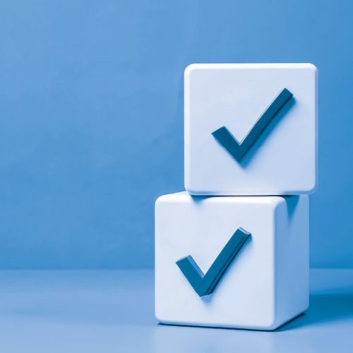Chairman’s Column: Every Effort Matters; Two white cubes with blue check marks stacked against a blue background convey a sense of approval and completion. Modern and minimalist design.